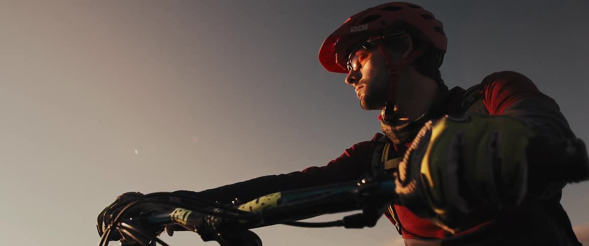 A man is sitting on his bicycle and wearing helmet