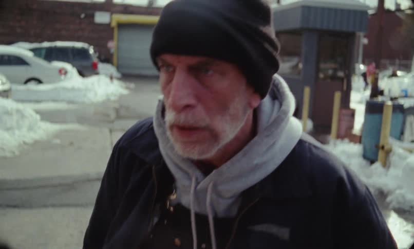 An older man is walking outside and he looks angry