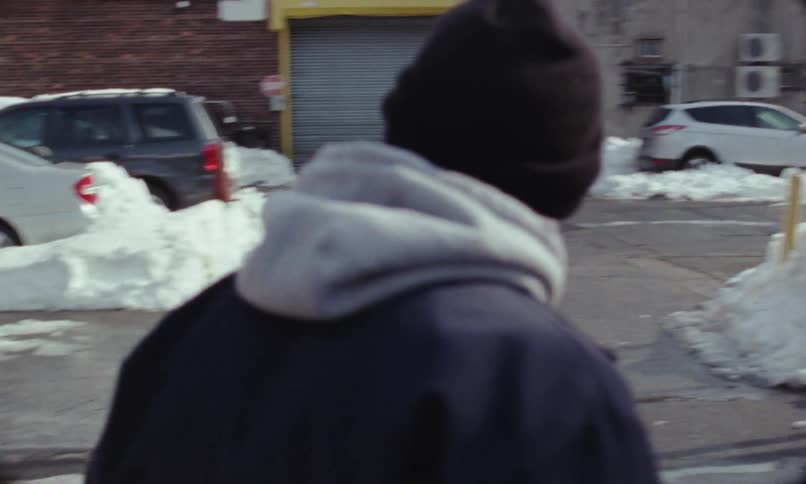 A man is walking through a suburban city during winter