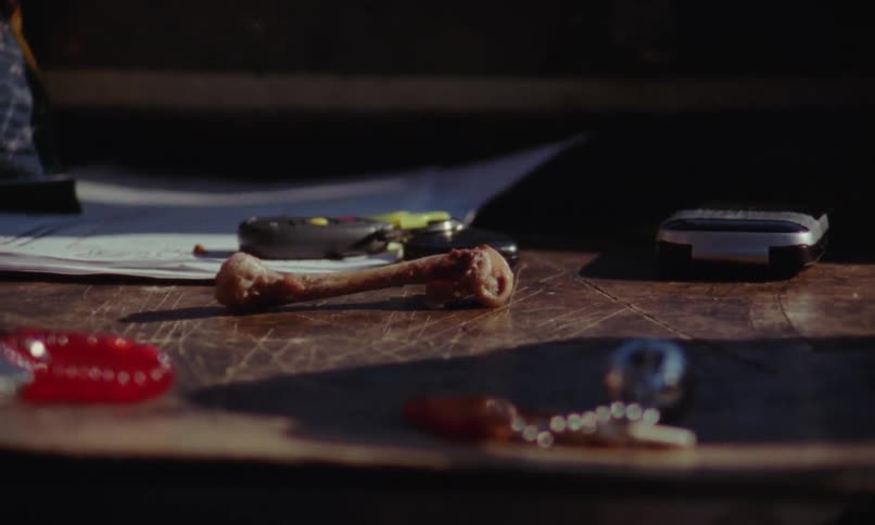 A close up of a bone without meat on it and then a wide shot of miscellaneous items on a table