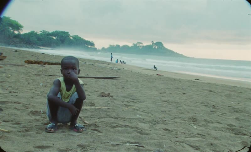 The view is of a kid that is sitting on the beach
