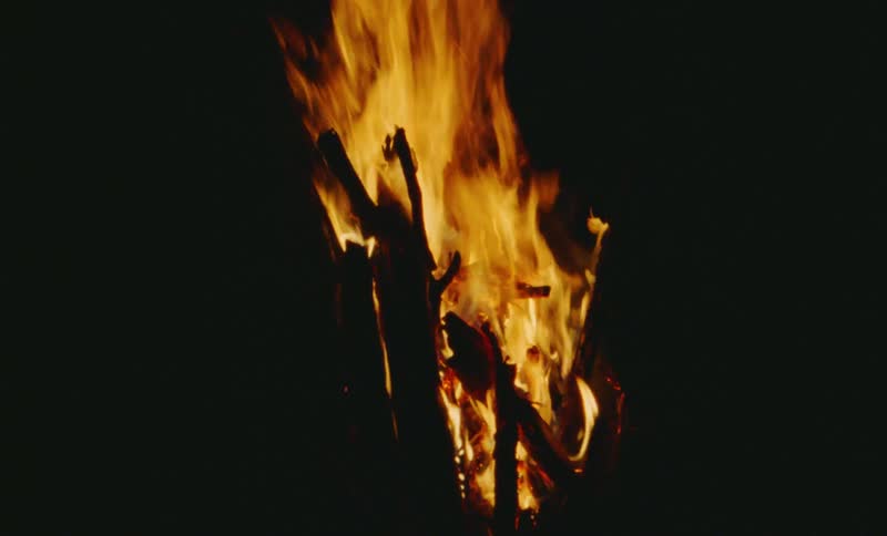 Close up view of a bonfire during the night time is displayed