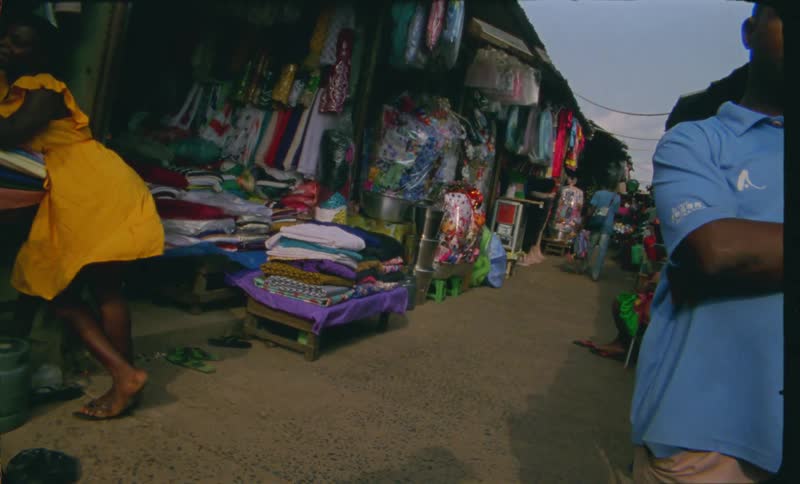 People stand and walk through open air market
