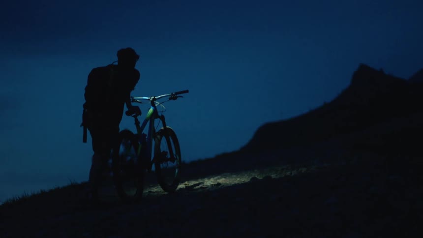 The view is of a guy with his bike around night time