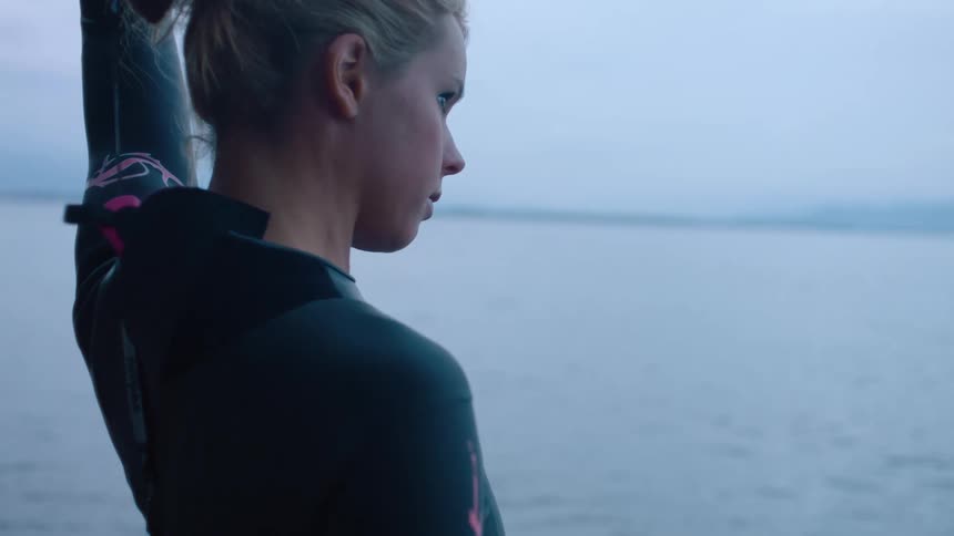 A female is getting ready to surf in the ocean water