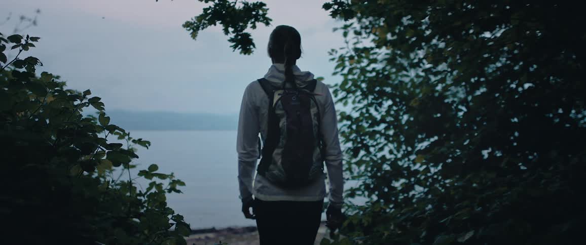 A woman walking toward a beach of somekind