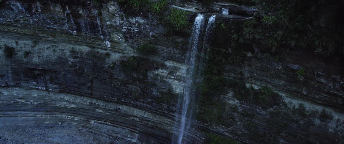 The view is of a water fall in the middle of the day time