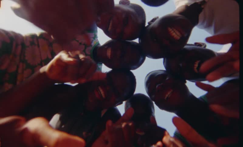 A group of young african teenage women pose around a camera and make fun gestures at it