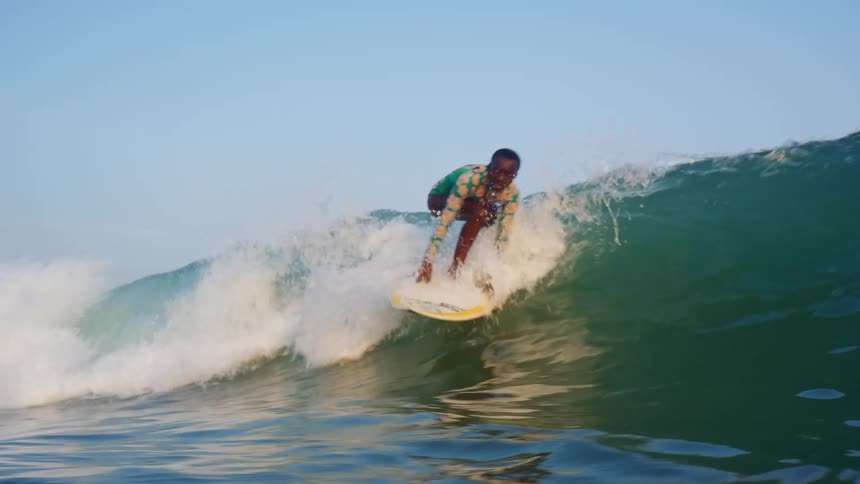 A young boy on a surf boardriding a wave on the ocean