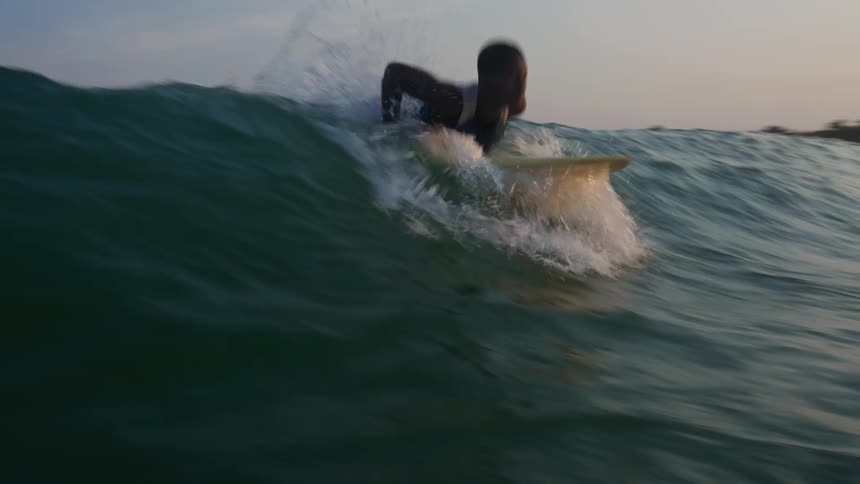 A group of people are surfing on the ocean water together