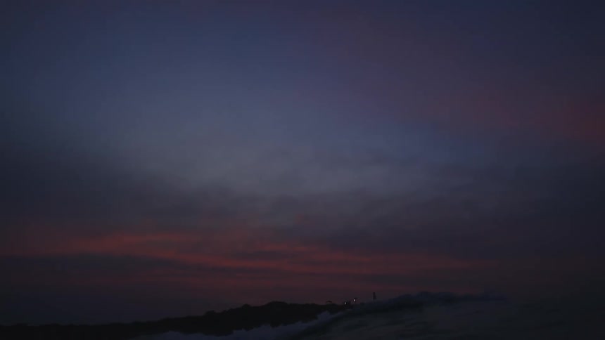 The sun is setting above the ocean water
