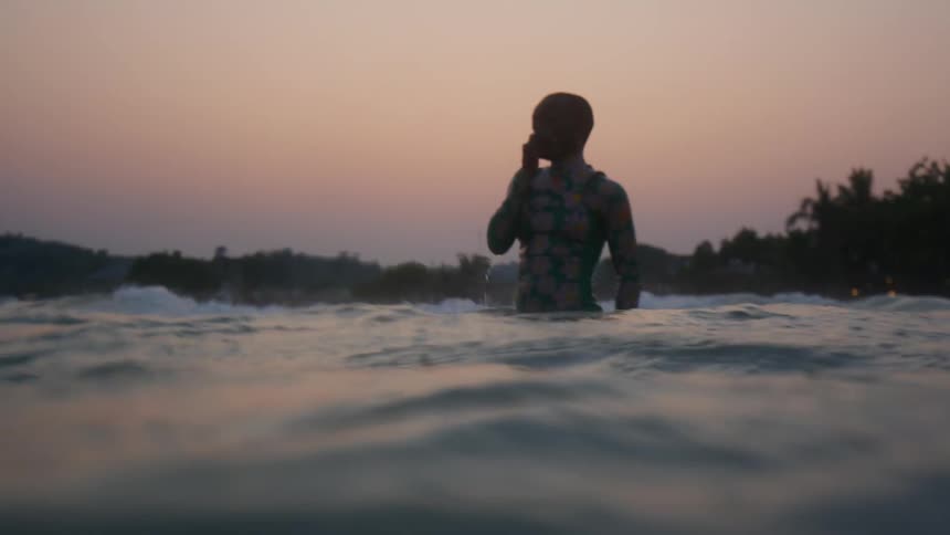 A woman wlaking in the ocean