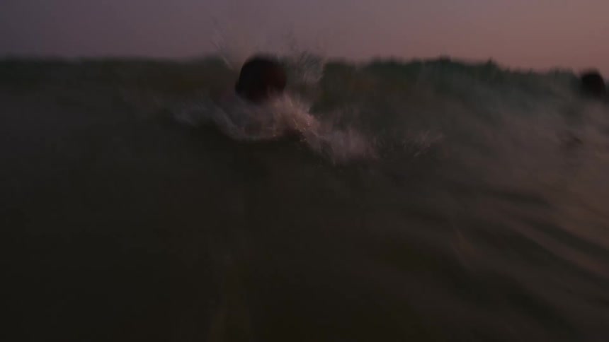 Time lapse of children playing in sea at sunset