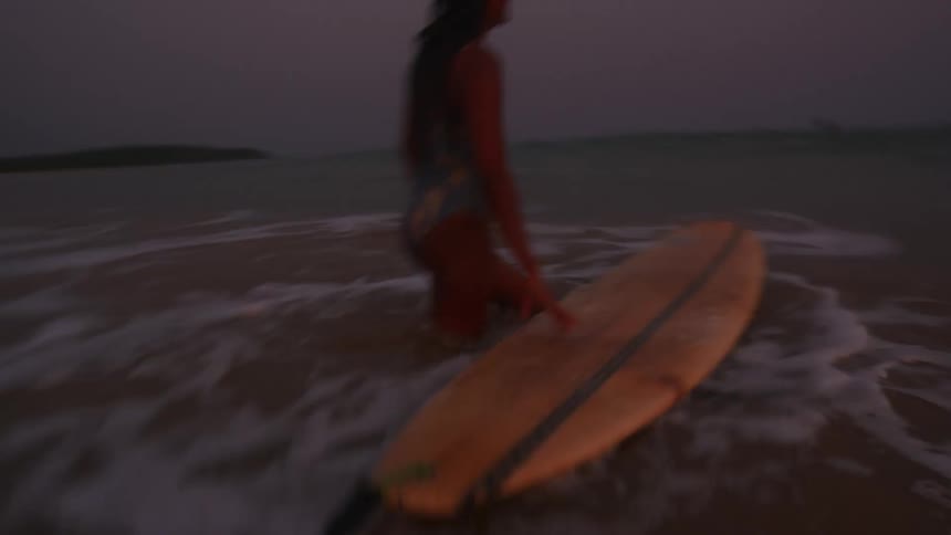 The view is of people surfing in the water around the day time