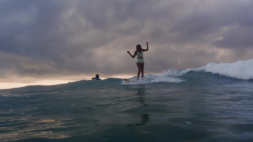 Two people are surfing in the ocean water together