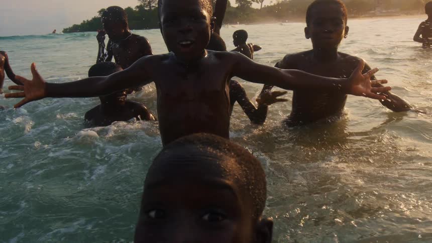 A group of children are swimming in ocean water