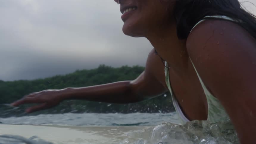 A female is surfing in the ocean during the spring