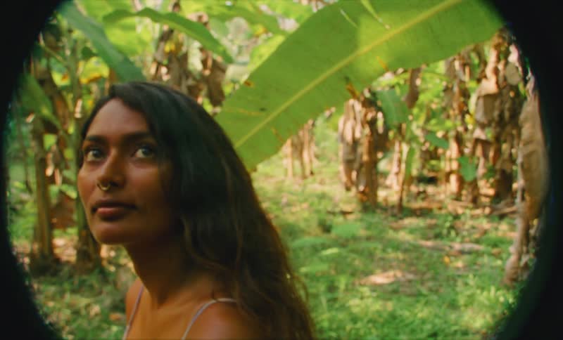 Film footage of a female standing in a tropical landscape