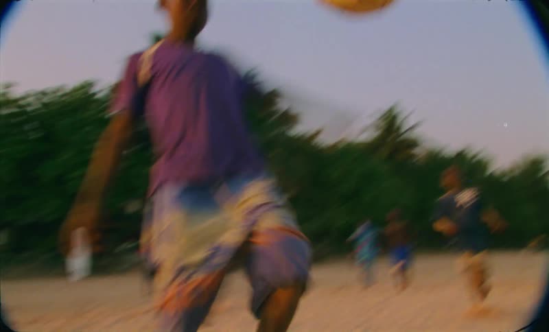 A young boy is working a ball with some soccer moves on the beach