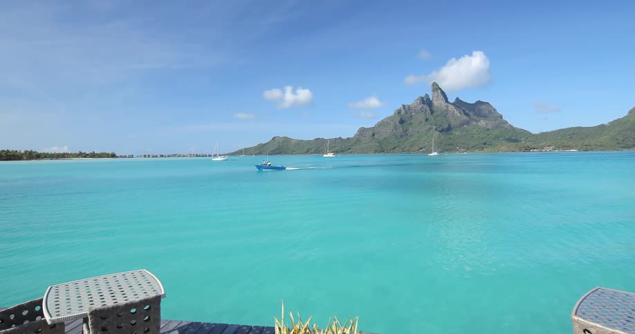 A boat moves across turquoise blue water
