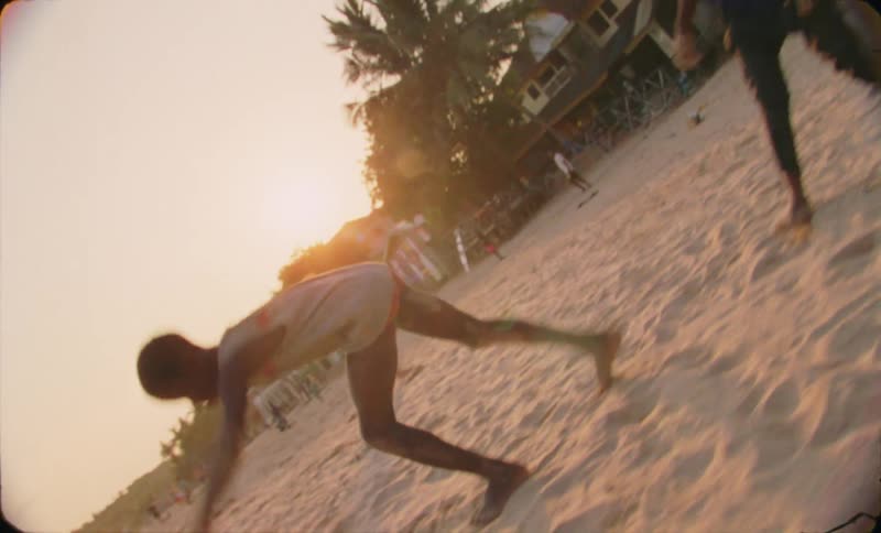 Young kids doing handstands over the sand next to the ocean at sunset caught on vintage film
