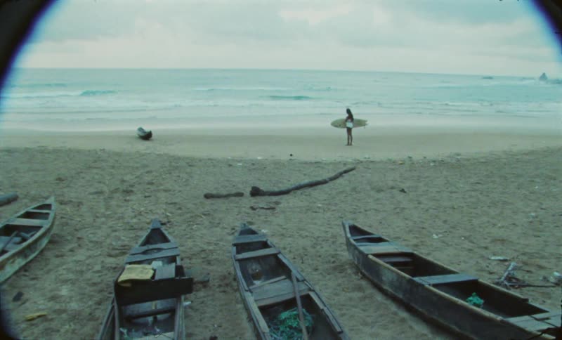 The view is of a person holding there surfboard on the beach