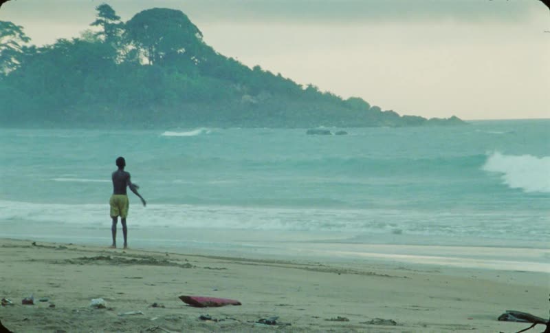 A kid is kicking a ball at the beach