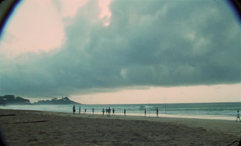 A group of men play volleyball along the coast