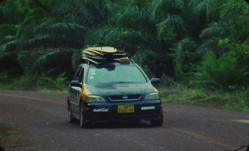 Taxi with surfboards drive on highway in the forest