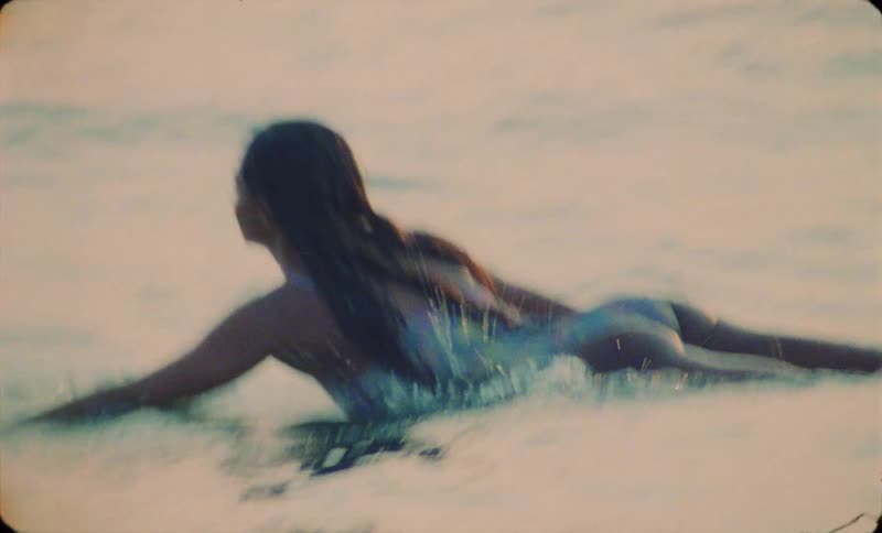 A young woman is surfing on the ocean