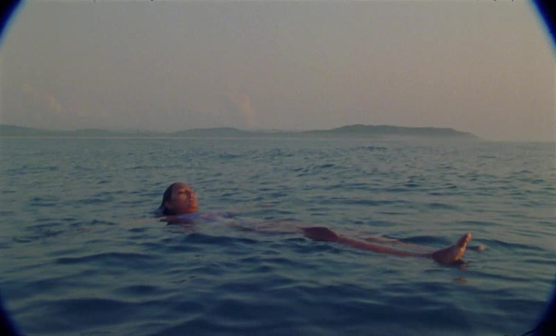 A young woman is swimming outdoors in the ocean