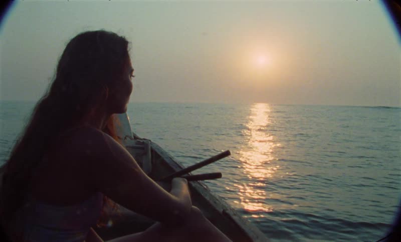 A female is riding on a boat over ocean water