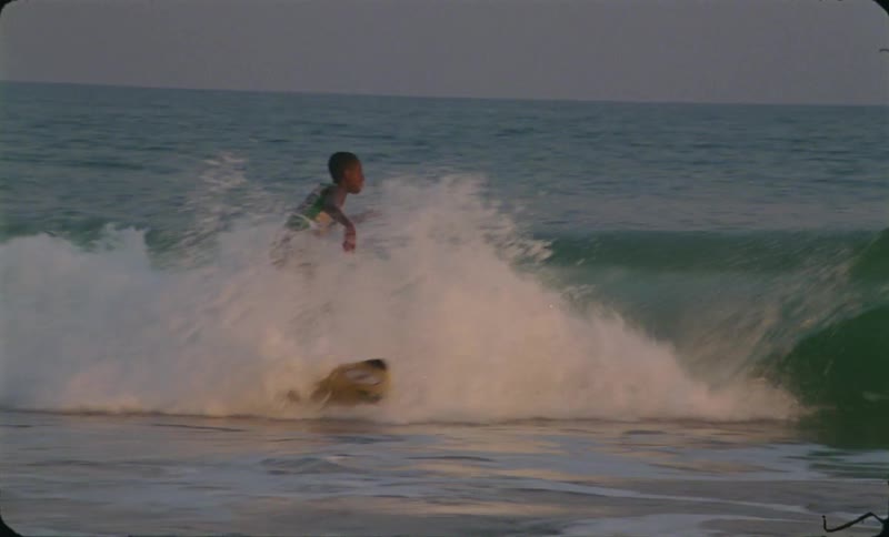 People are surfing on ocean waves at dusk