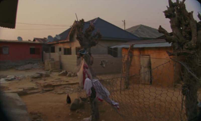 A group of improvised shacks on a shanty town at evening caught on vintage film
