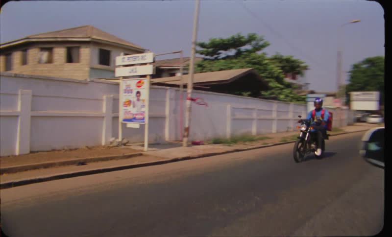 The view is of car driving downing the road around the city area