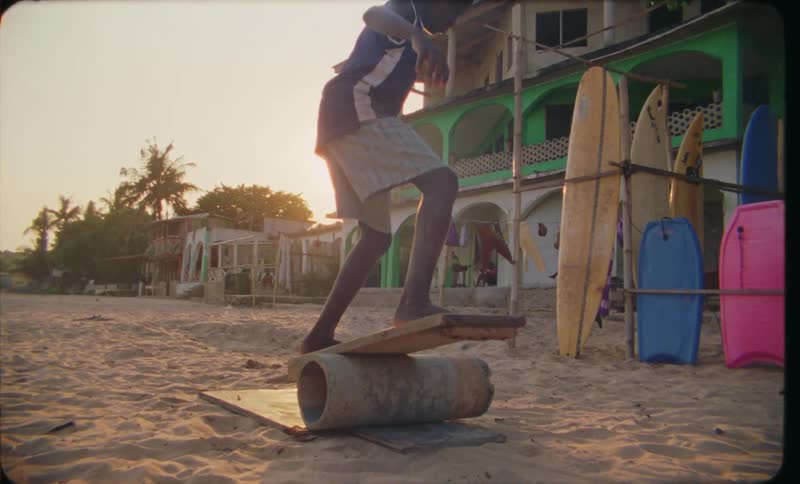 Young boy practices balance over a concrete pipe caught on vintage film