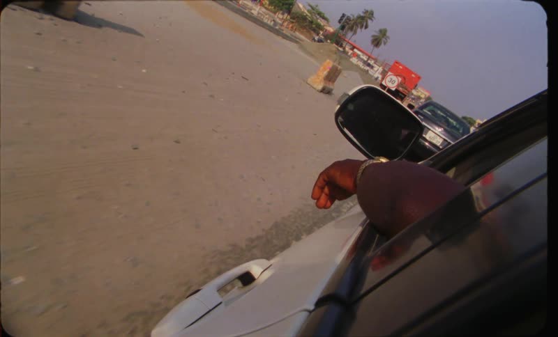 Looking outside the car window driving along beach boardwalk pov from back seat