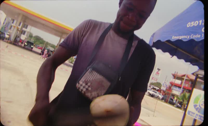 A person using a machete to cut a round piece of food and to shave the sides