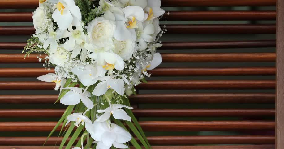 A flower bouquet has white flowers in a wreath
