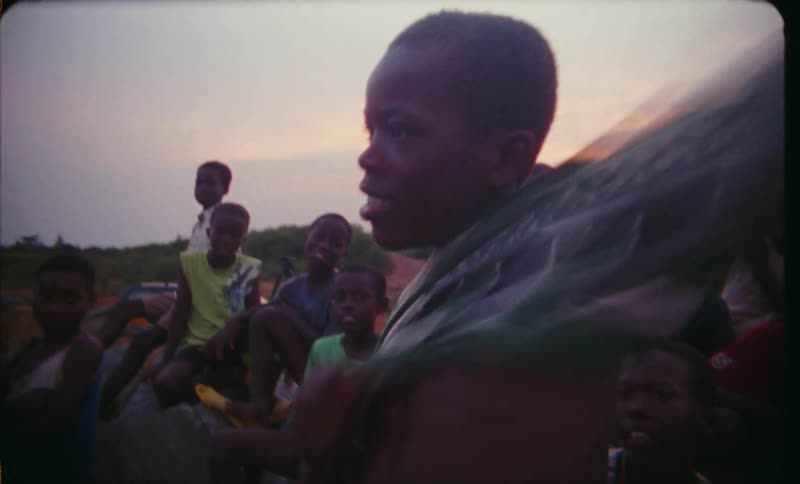 Boy puts on top outdoors as other youths watch