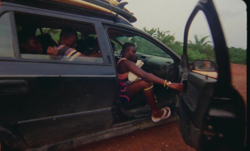 Group of people boarding a taxi on a rural dirt road in the tropics caught on vintage film