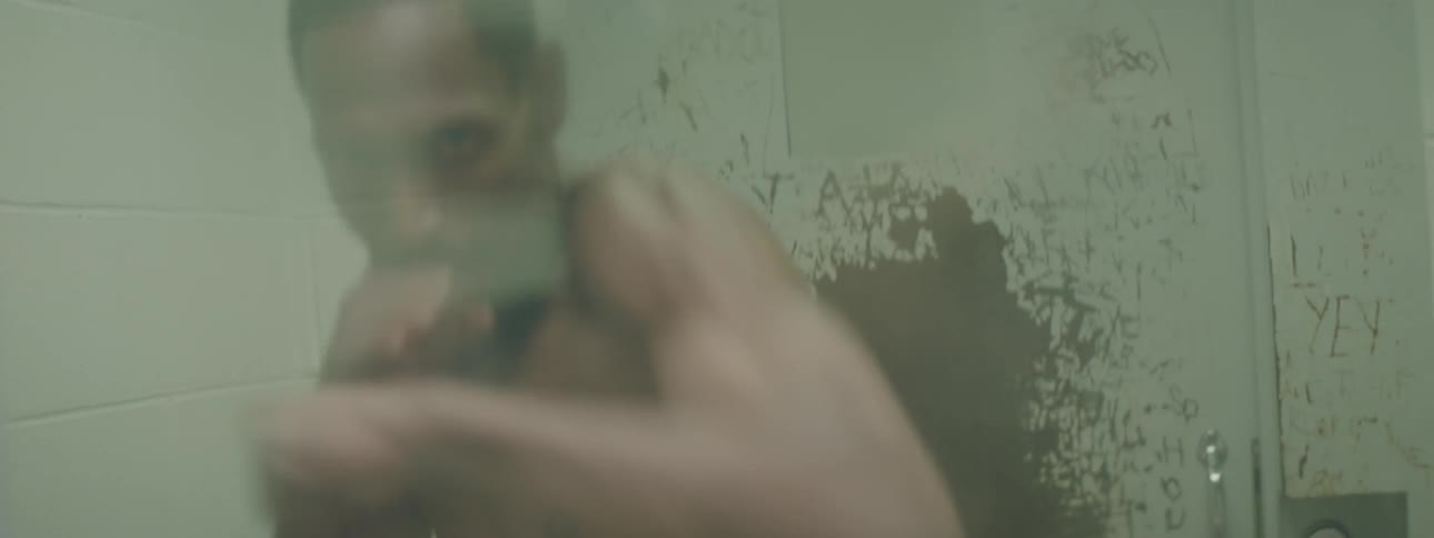 A man is boxing by himself in a prison cell