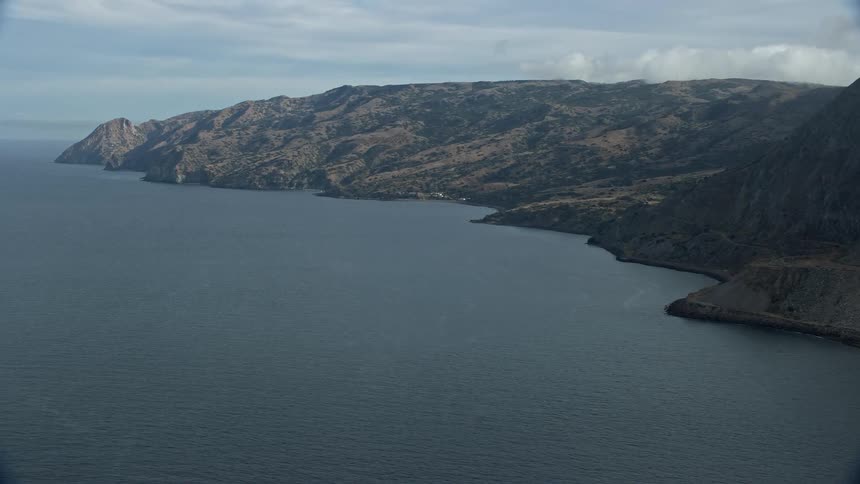 The aerial footage showcases the stunning Santa Catalina Island coastline with towering cliffs and crystal clear waters on a sunny day