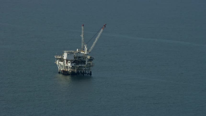 An epic aerial view of an oceanic derrick in Southern Californias offshore oil platform during the day