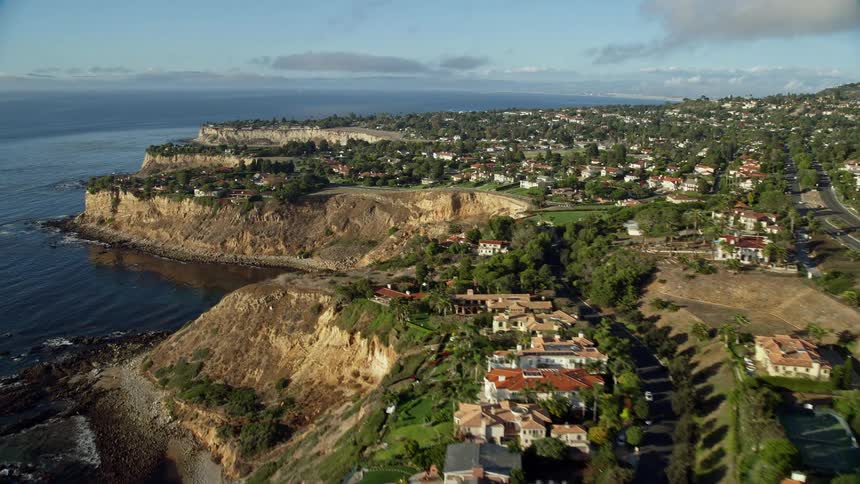 Fly over shot of luxurious clifftop mansions in Rancho Palos Verdes CA with breathtaking views of the shoreline beachfront property and surrounding coastal communities