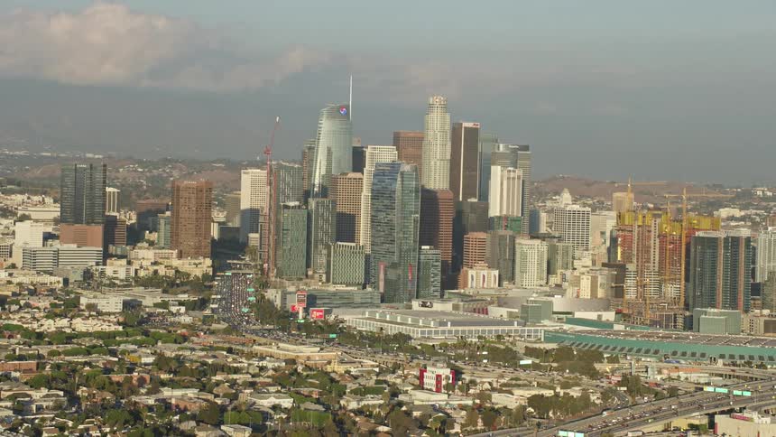 Aerial view of Downtown Los Angeles skyline with tall skyscrapers during a partly cloudy day