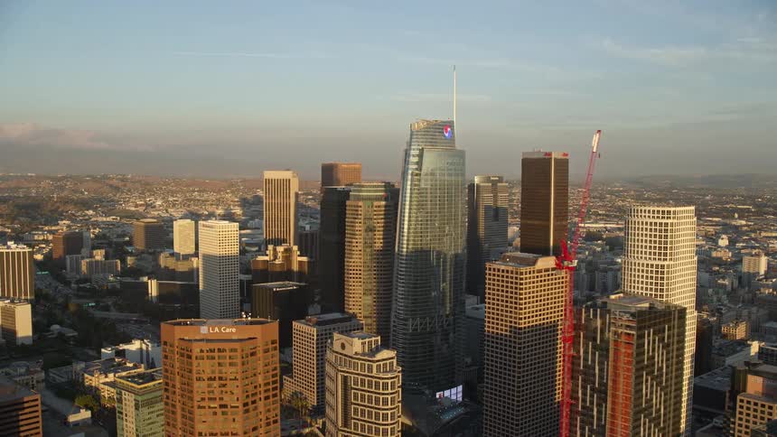 An aerial shot of downtown Los Angeles skyscrapers at sunset viewed from Oceanwide Plaza during summer