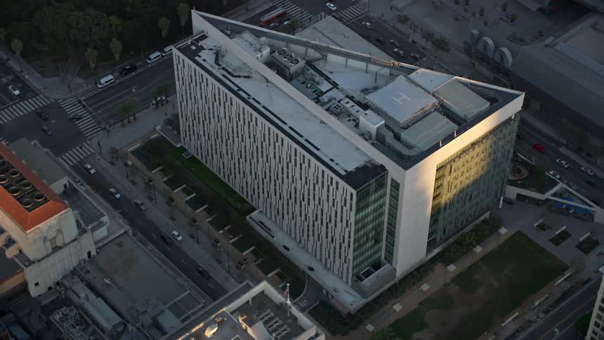A stunning aerial shot of LAPD headquarters at twilight in Downtown Los Angeles with clear skies and scenic views of the citys downtown areas