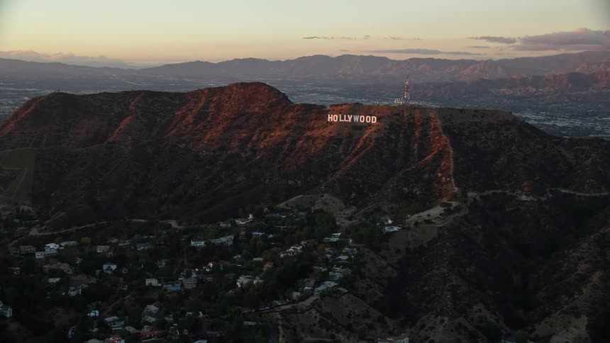 A aerial shot via Shotover F1 of the iconic Hollywood Sign in Los Angeles California during a partly cloudy twilight evening