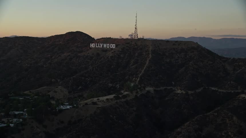 Approaching the iconic Hollywood Sign at twilight in Los Angeles California with a stunning panoramic view of the nearby mountains